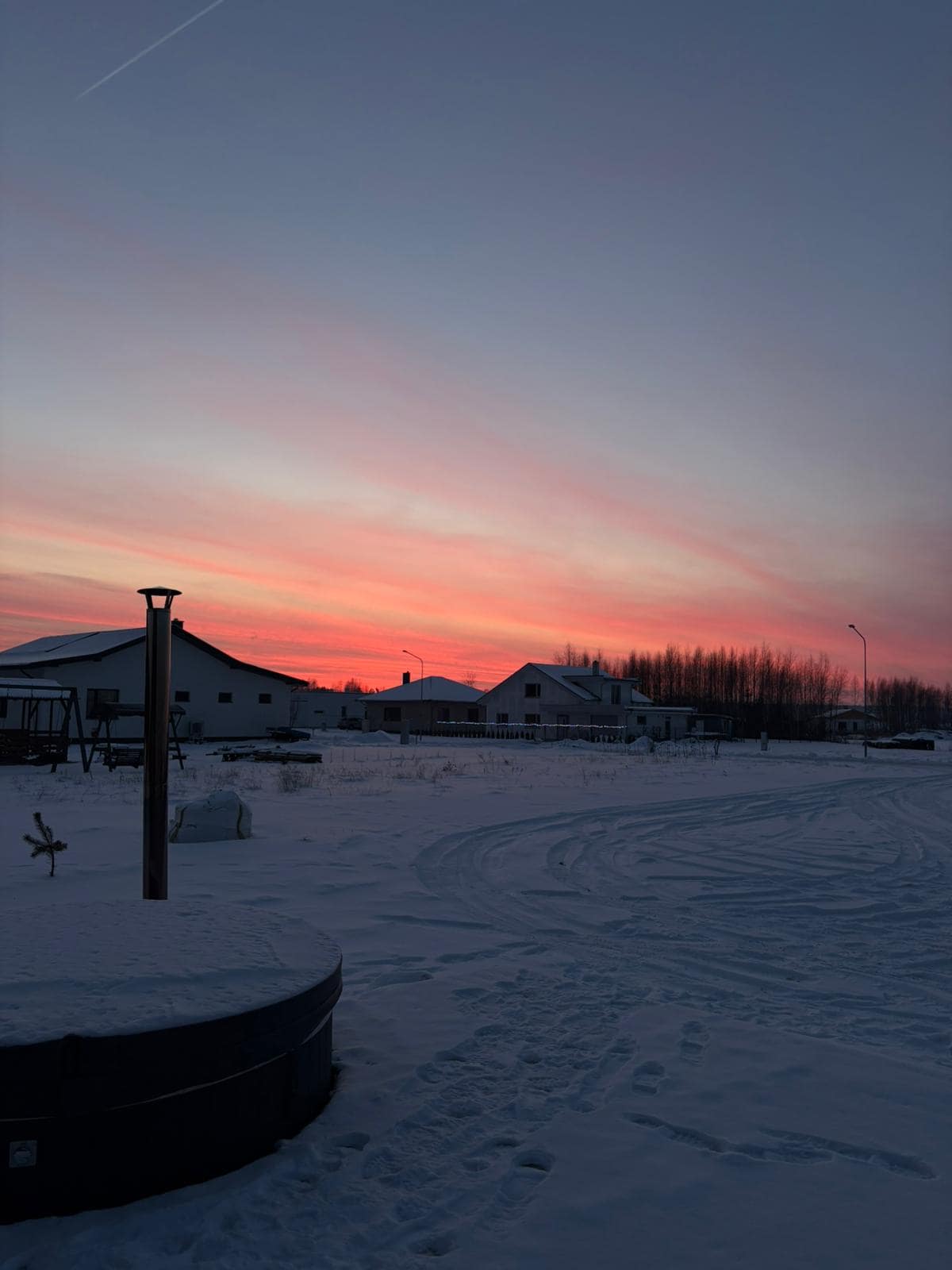 Sunset view with hot tub in snowy yard